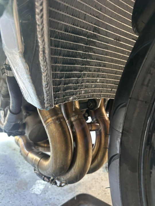 Coolant is leaking through the radiator and on the ground.