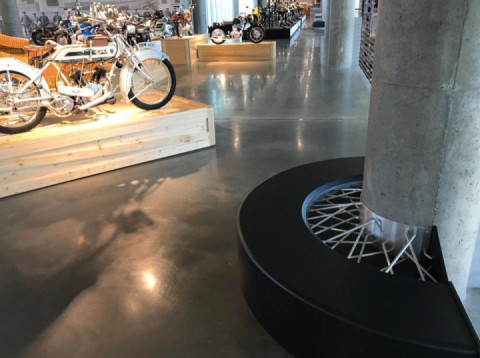 The bench at this motorcycle museum is made to look like a spoked wheel.