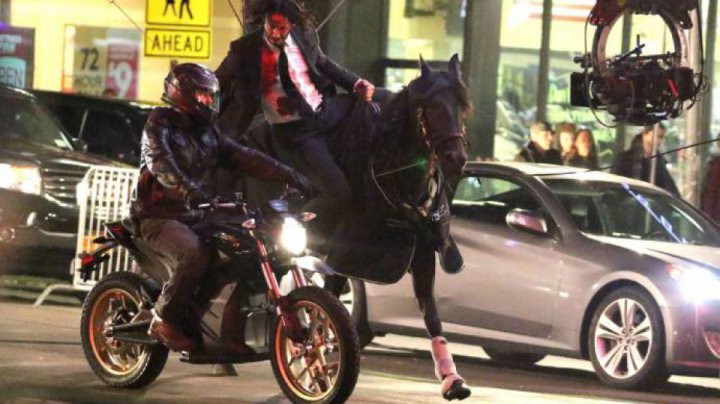 Keanu Reeves follows a motorcycle on a horse