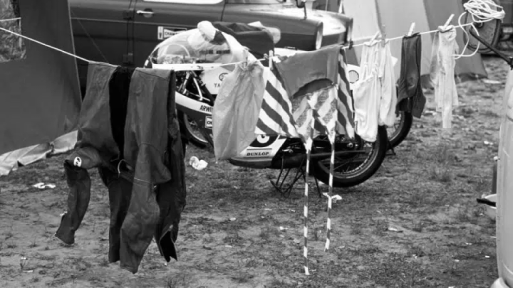 Washing hung out next to a motorcycle in the paddock at a 1970s Grand Prix