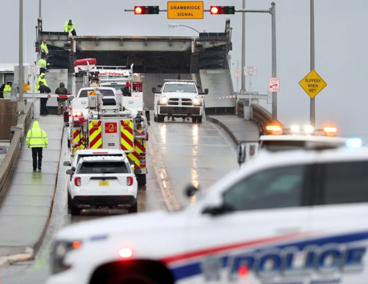 Crews work to pull up a motorcycle and the trailer it was pulling from over the edge of the Main Street bridge, Saturday, March 12, 2022, following a crash on the bridge.