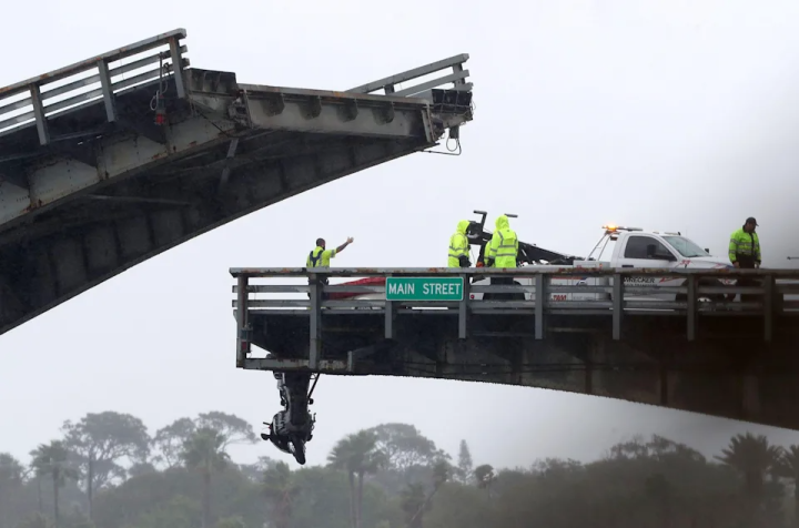 Crews work to pull up a motorcycle from over the edge of the Main Street bridge, Saturday, March 12, 2022, following a crash on the bridge.